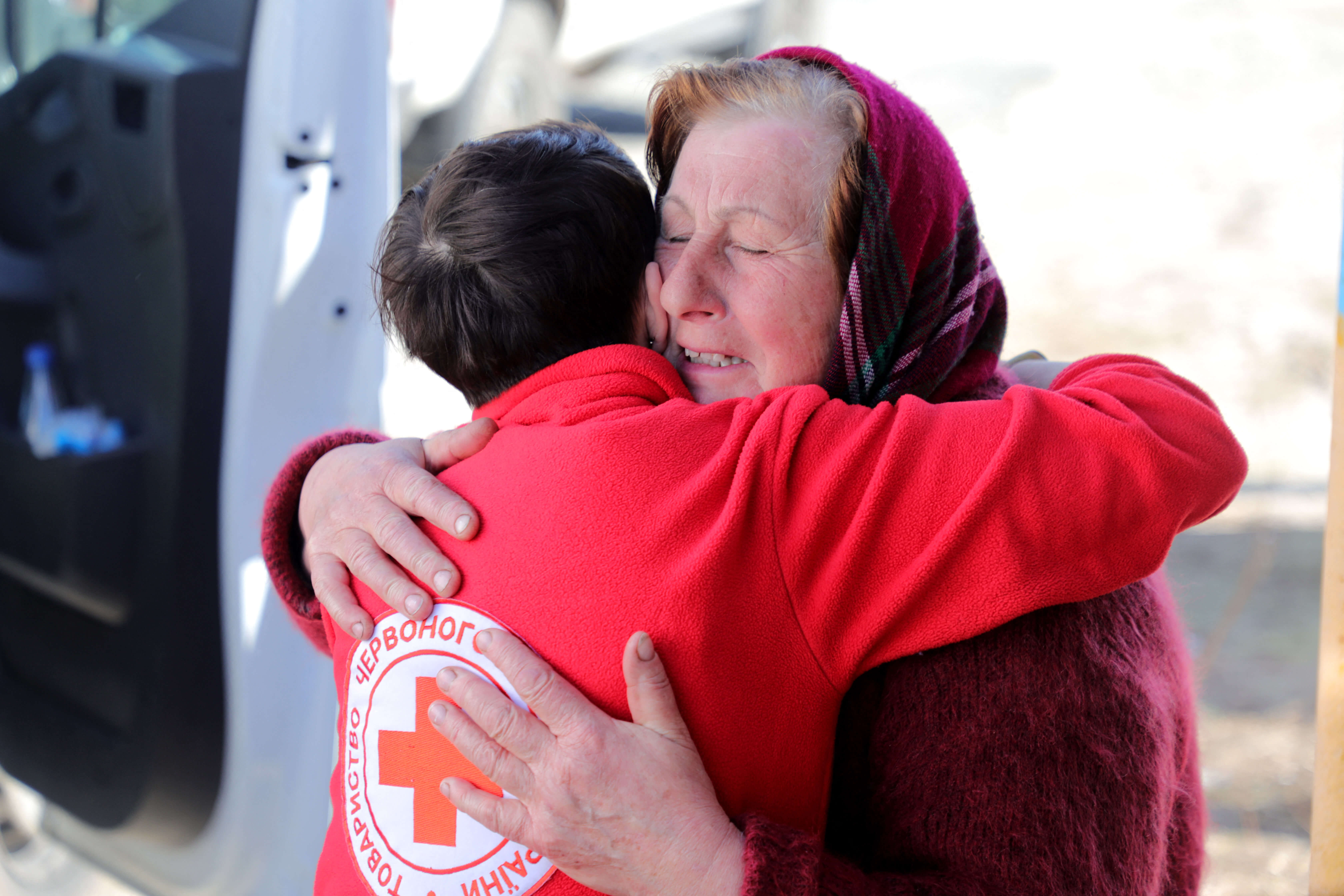 Klep - Een medewerker van het Rode Kruis omhelst een Oekraïnse vrouw ten noorden van Kiev in april 2022. Reuters
