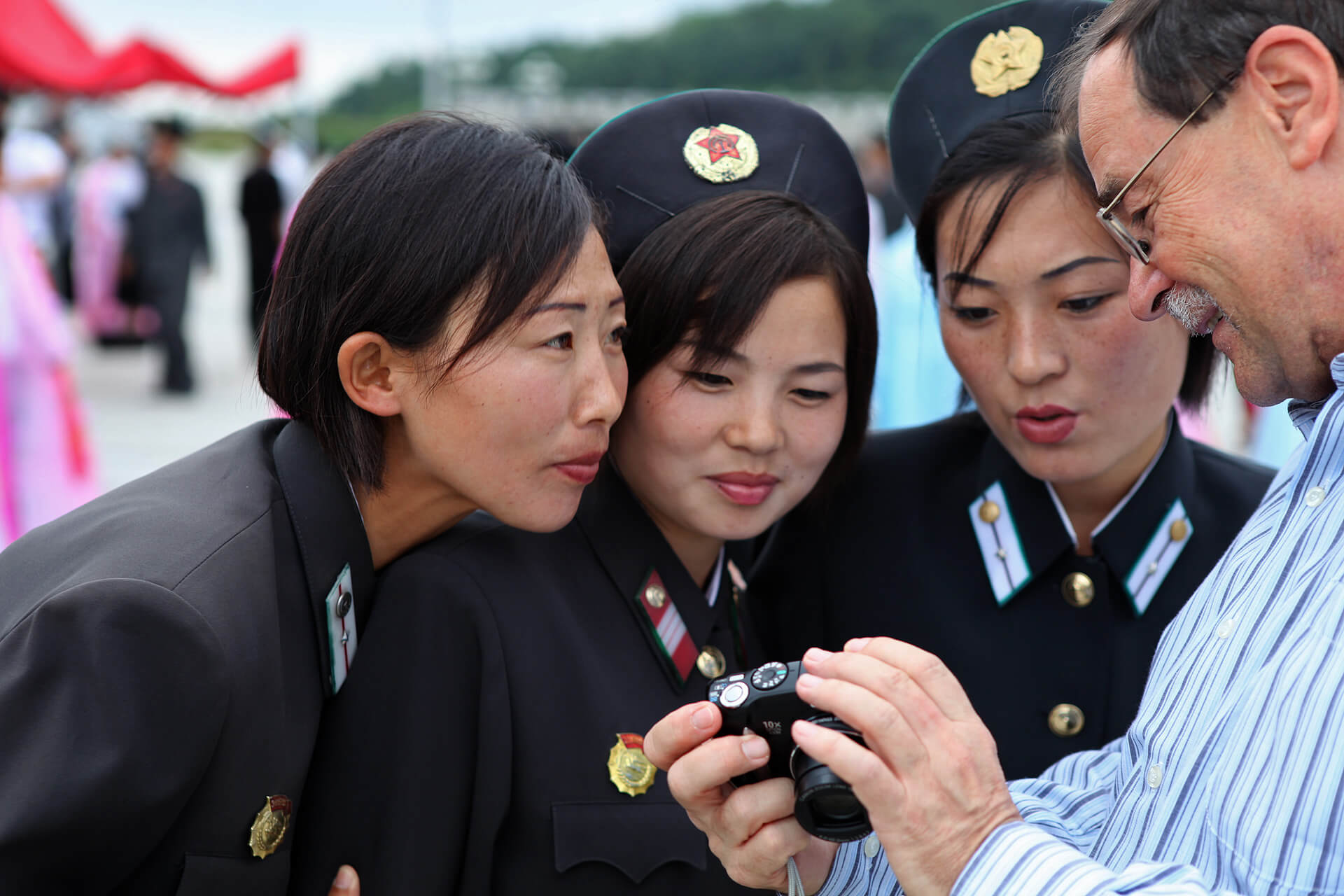 A tourist shows his pictures to North Koreans in the capital