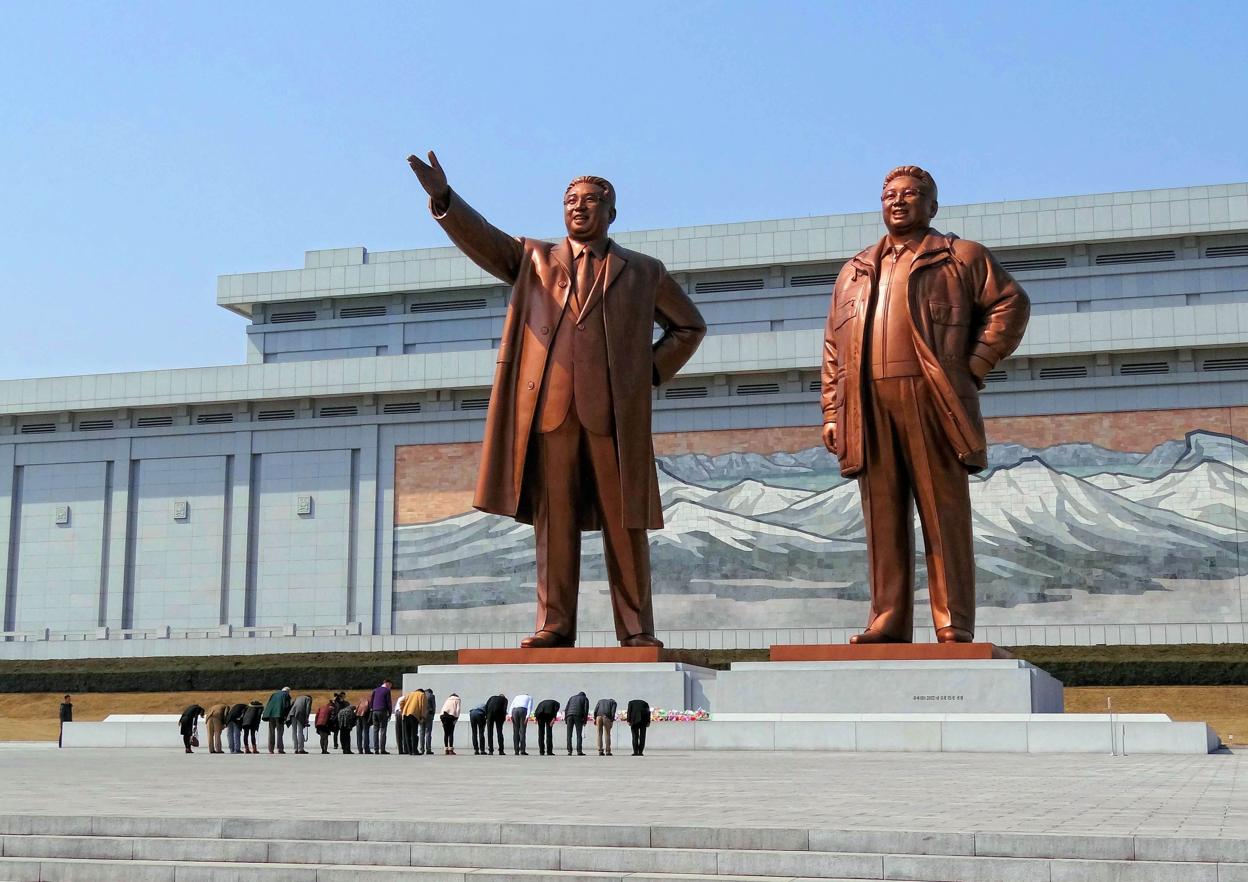 Visitors bowing in a show of respect for North Korean leaders Kim Il-sung and Kim Jong-il on Mansudae (Mansu Hill) in Pyongyang, North Korea.-wikicommons.jpg