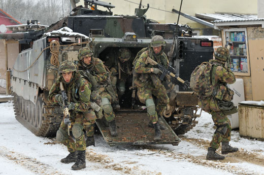 Nederlandse soldaten springen uit een CV-90 pantsergevechtsvoertuig tijdens een militaire oefening