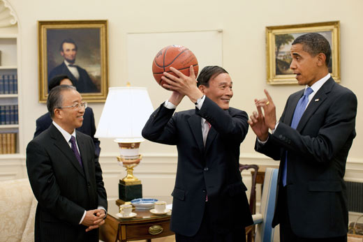 De toenmalige Chinese vice-premier Wang Qishan houdt de door president Obama gesigneerde basketbal vast na de eerste US–China Strategic and Economic Dialogue in 2009.