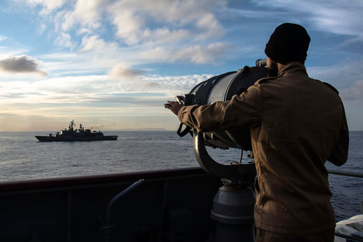 A sailor of SNMG2 flagship German frigate HAMBURG is visually sending a message in morse code via spotlight in November 2015, during Operation Active Endeavour.