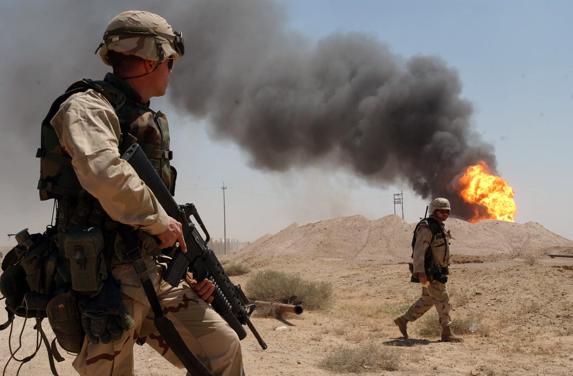 Amerikaanse mariniers naast een brandende oliebron in Zuid-Irak tijdens operatie 'Iraqi Freedom' in 2003 © WikiCommons-Arlo K. Abrahamson