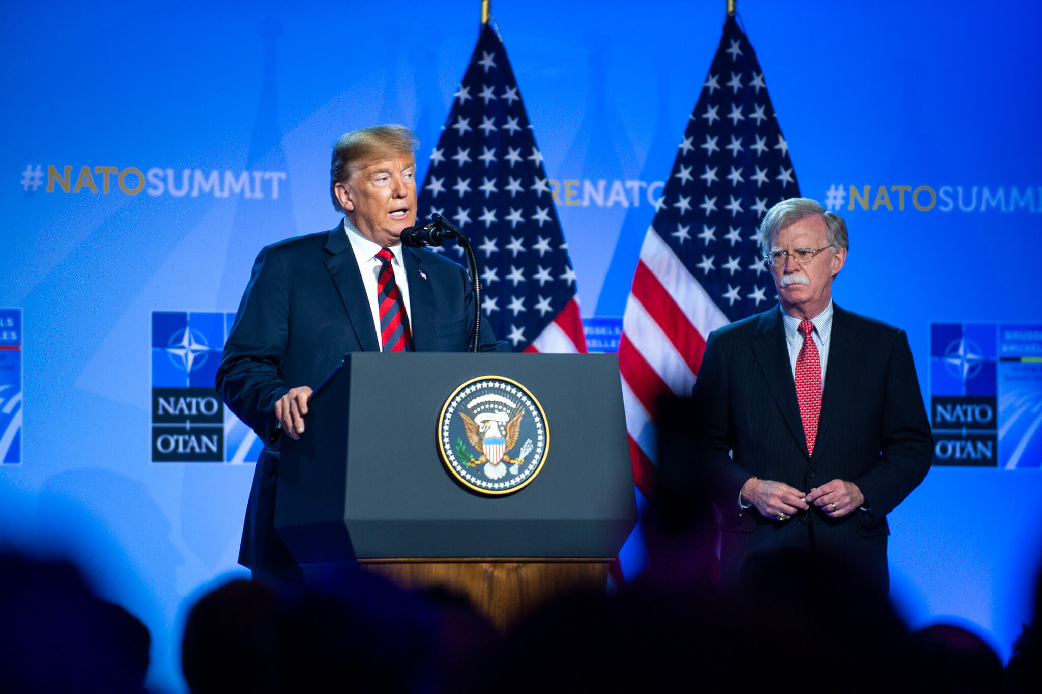 President Donald Trump samen met toenmalig National Security Advisor John Bolton tijdens een NAVO-top in 2018. © NATO