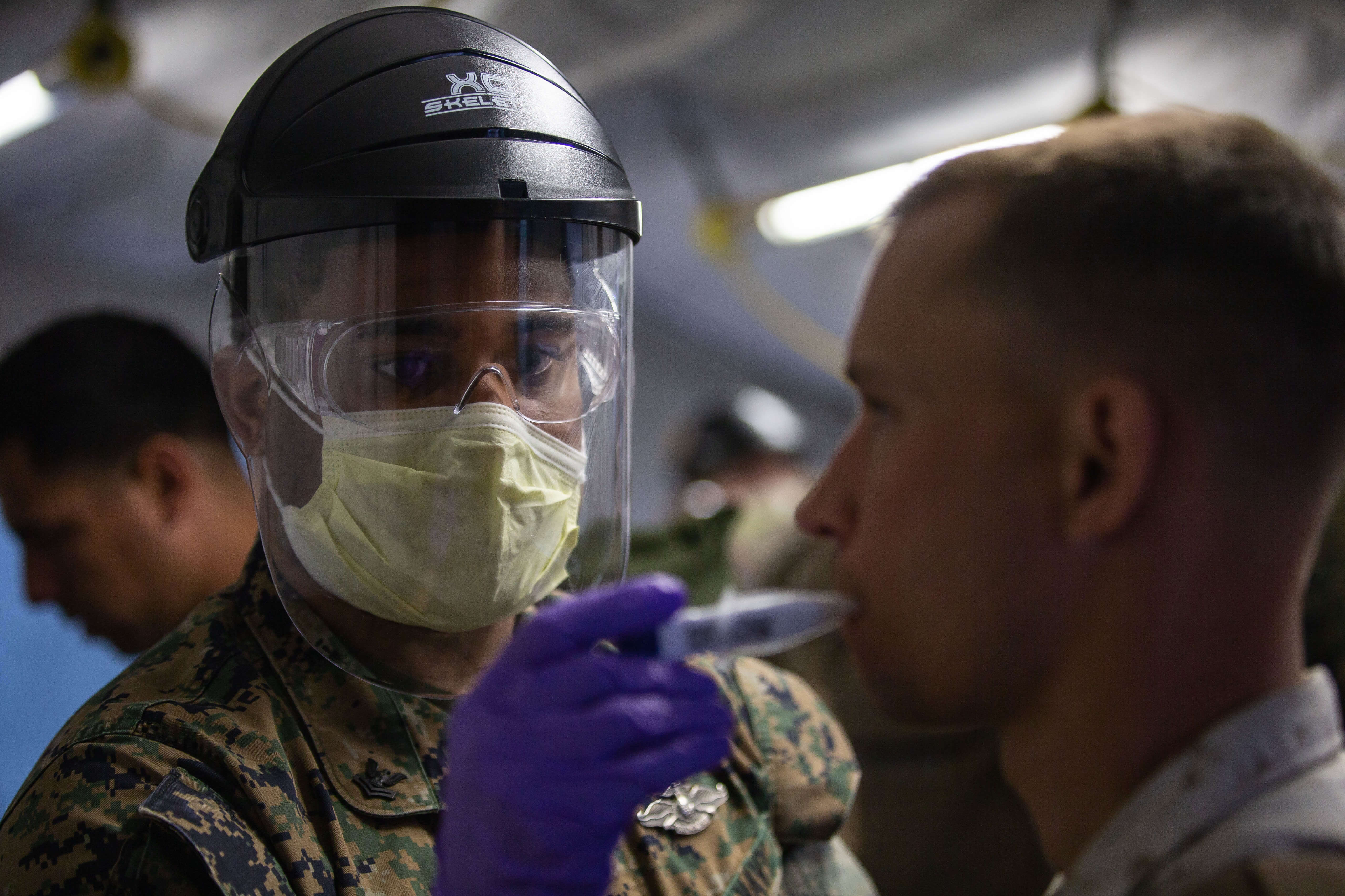 Een Amerikaanse marinier wordt getest op temperatuur om verspreiding van het coronavirus te voorkomen. © Marines - Flickr