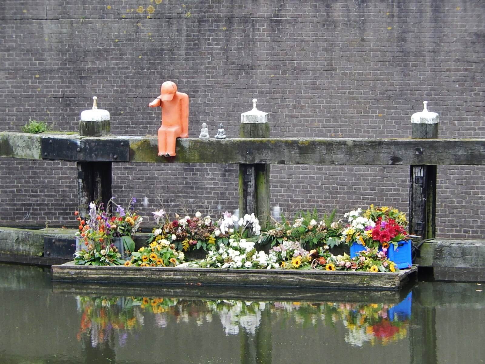 Bloemen ter nagedachtenis van de maker van het oranje kunstwerk, die omkwam bij de MH17 ramp. ©Flickr/Michael Coghlan