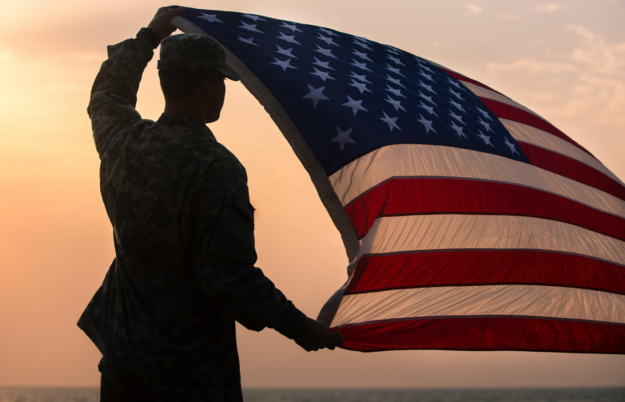 Hoekstra-foto3-U.S. Army communication specialist holds up the U.S. flag during a ceremony at Barclay Training Center in Liberia-Ja. 1 2015- -DVIDSHUB-Flickr-U.S. Army photo by Spc. Rashene Mincy, 55th Signal Company