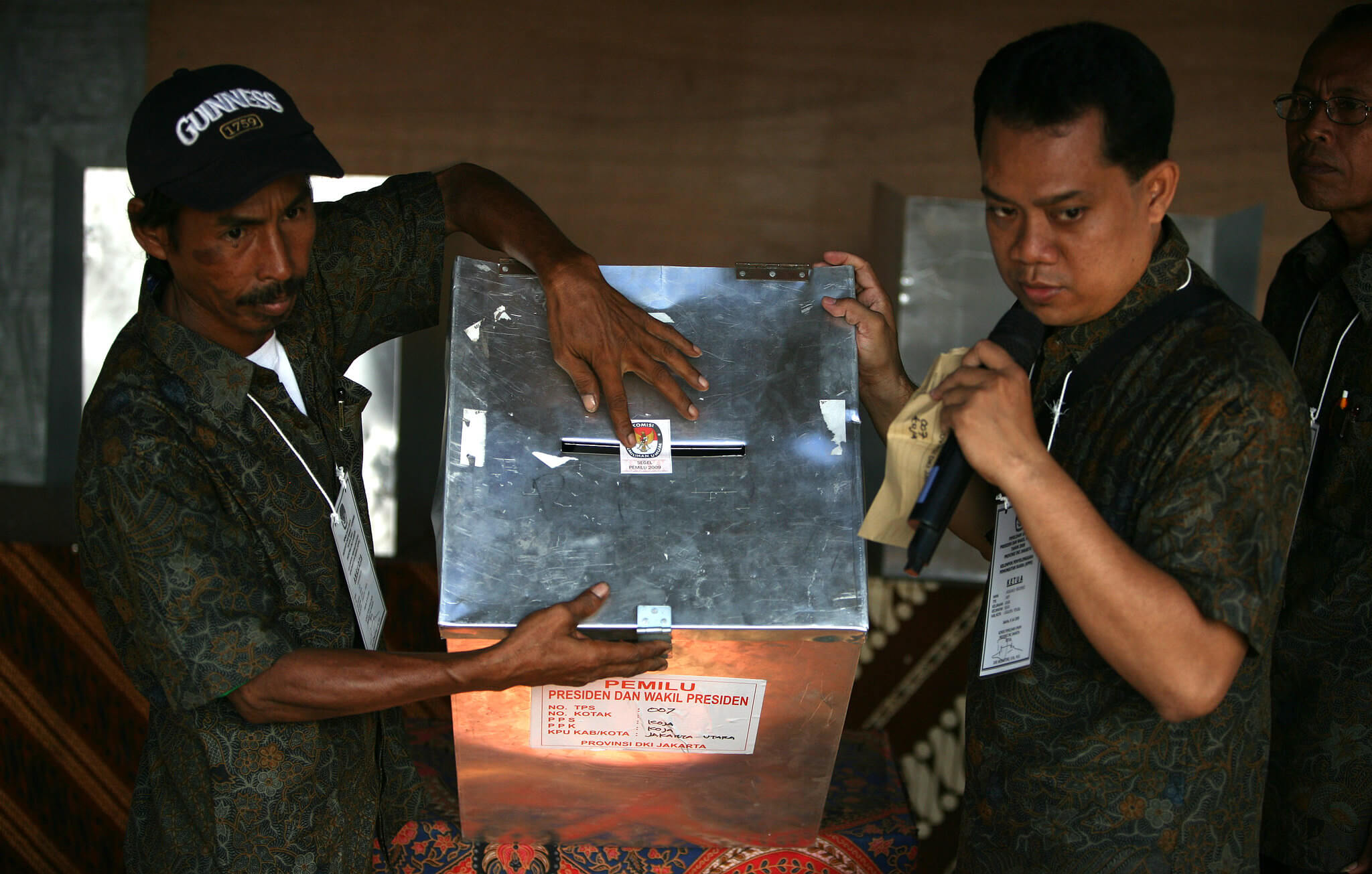 Two polling booth attendants seal a ballot box full of votes. ©Flickr/Department of Foreign Affairs and Trade Australia