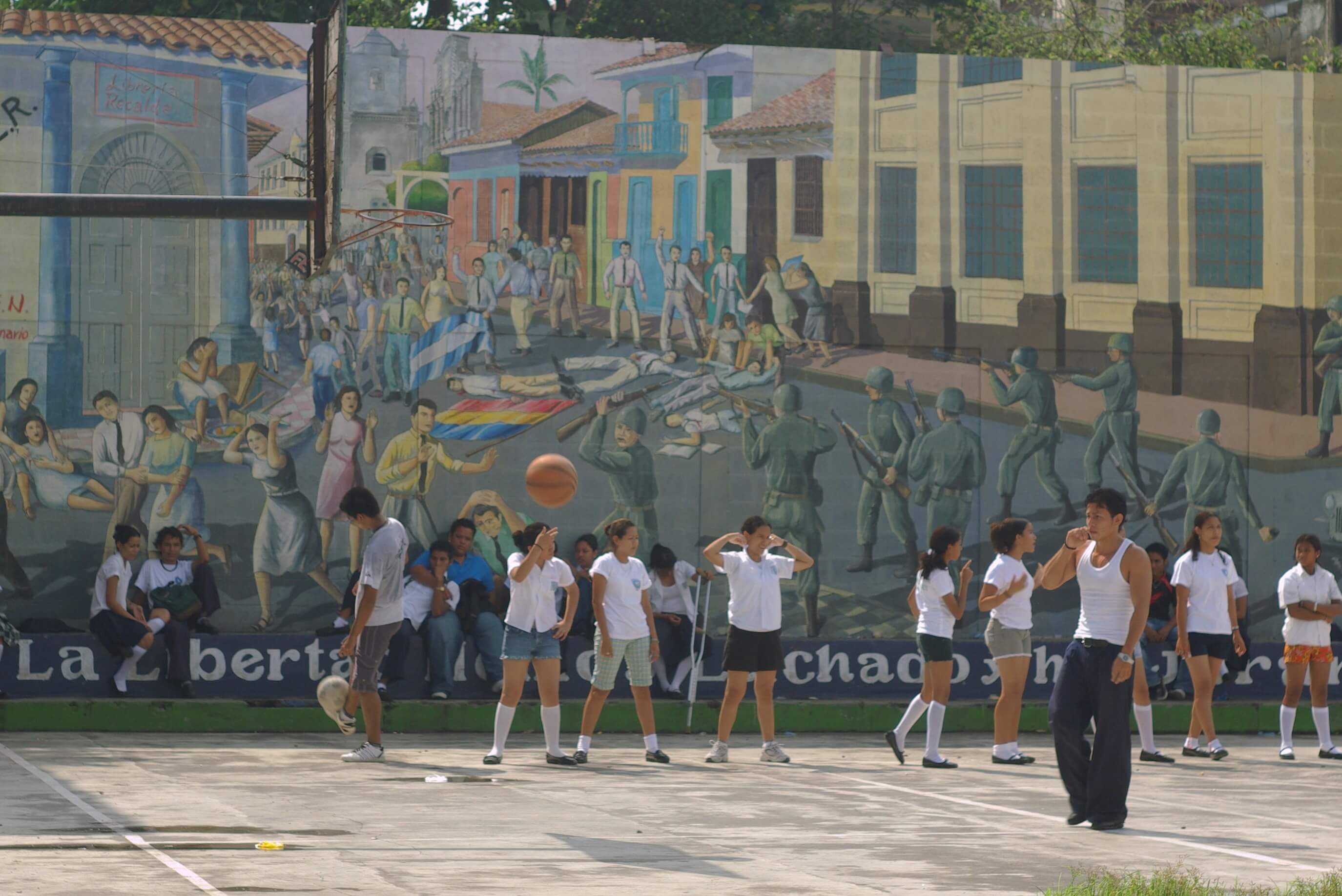Kinderen spelen op een pleintje voor een muurschildering ter ere van de revolutie  ©  Adam Baker / Flickr.