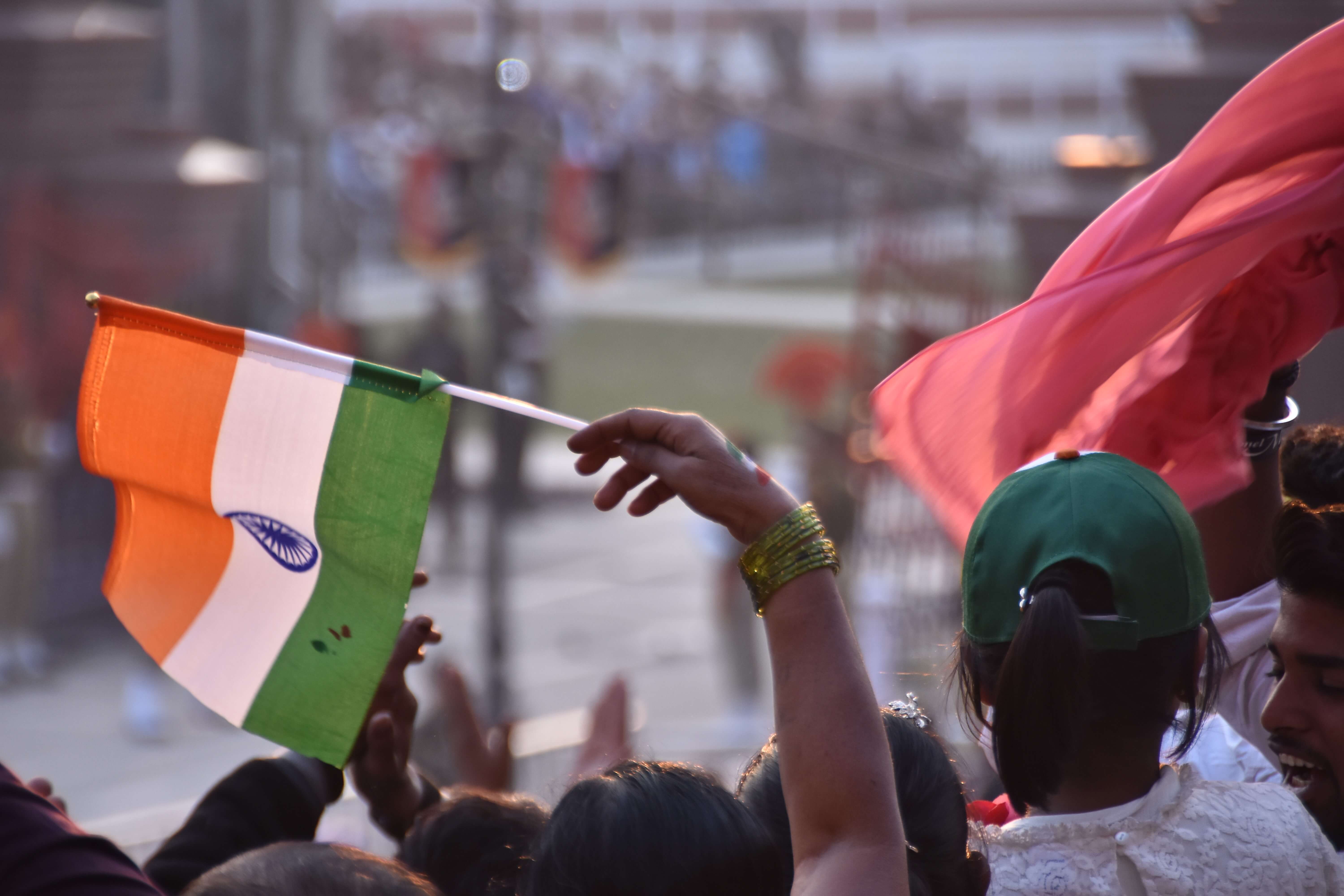 Een bezoeker zwaait met een Indiase vlag bij de grens ceremonie met India en Pakistan. © Shankas S./Flickr