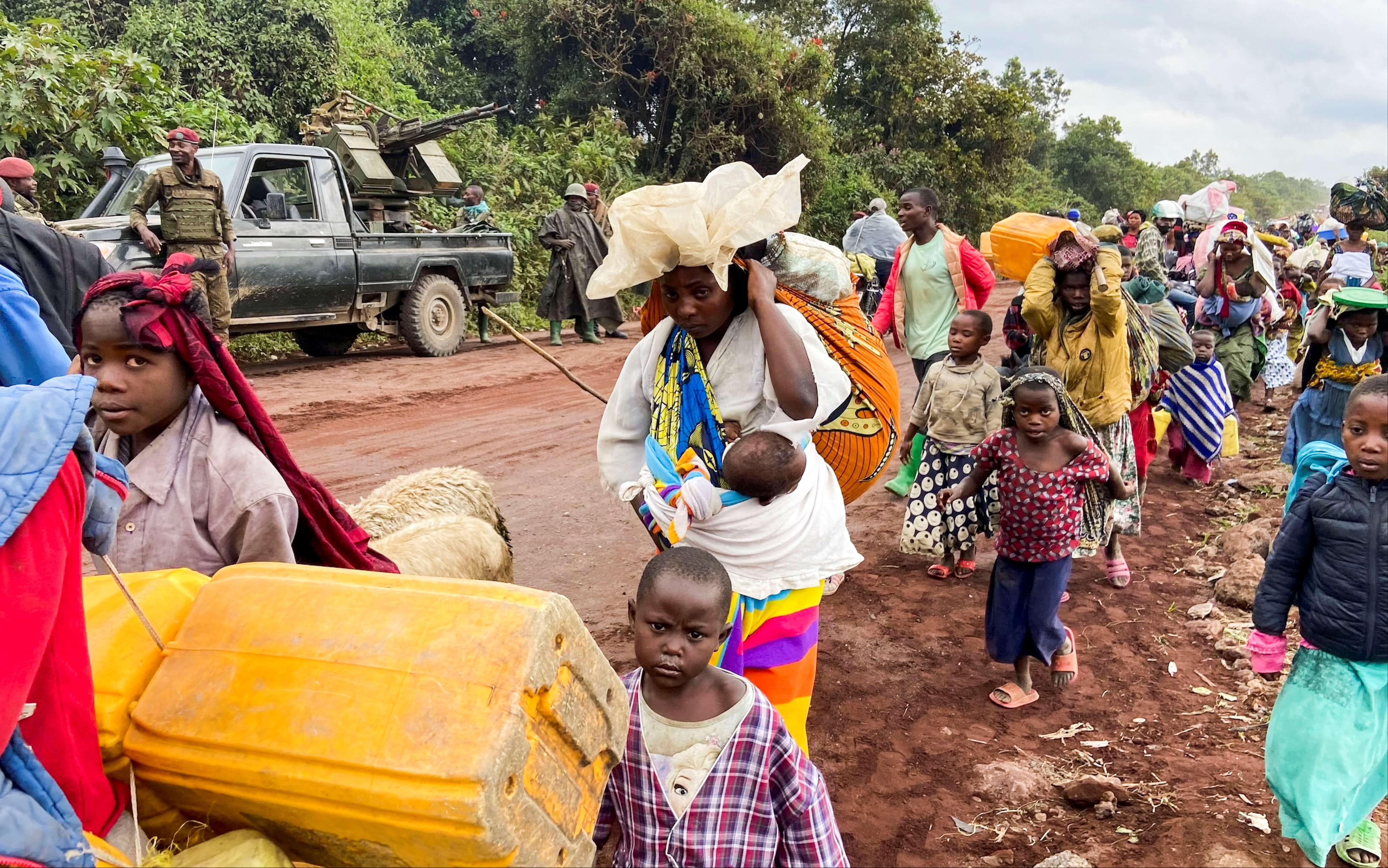 Congolese civilians carry their belongings as they flee near the Congolese border with Rwanda after fightings broke out in Kibumba, outside Goma in the North Kivu province of the Democratic Republic of Congo May 24, 2022