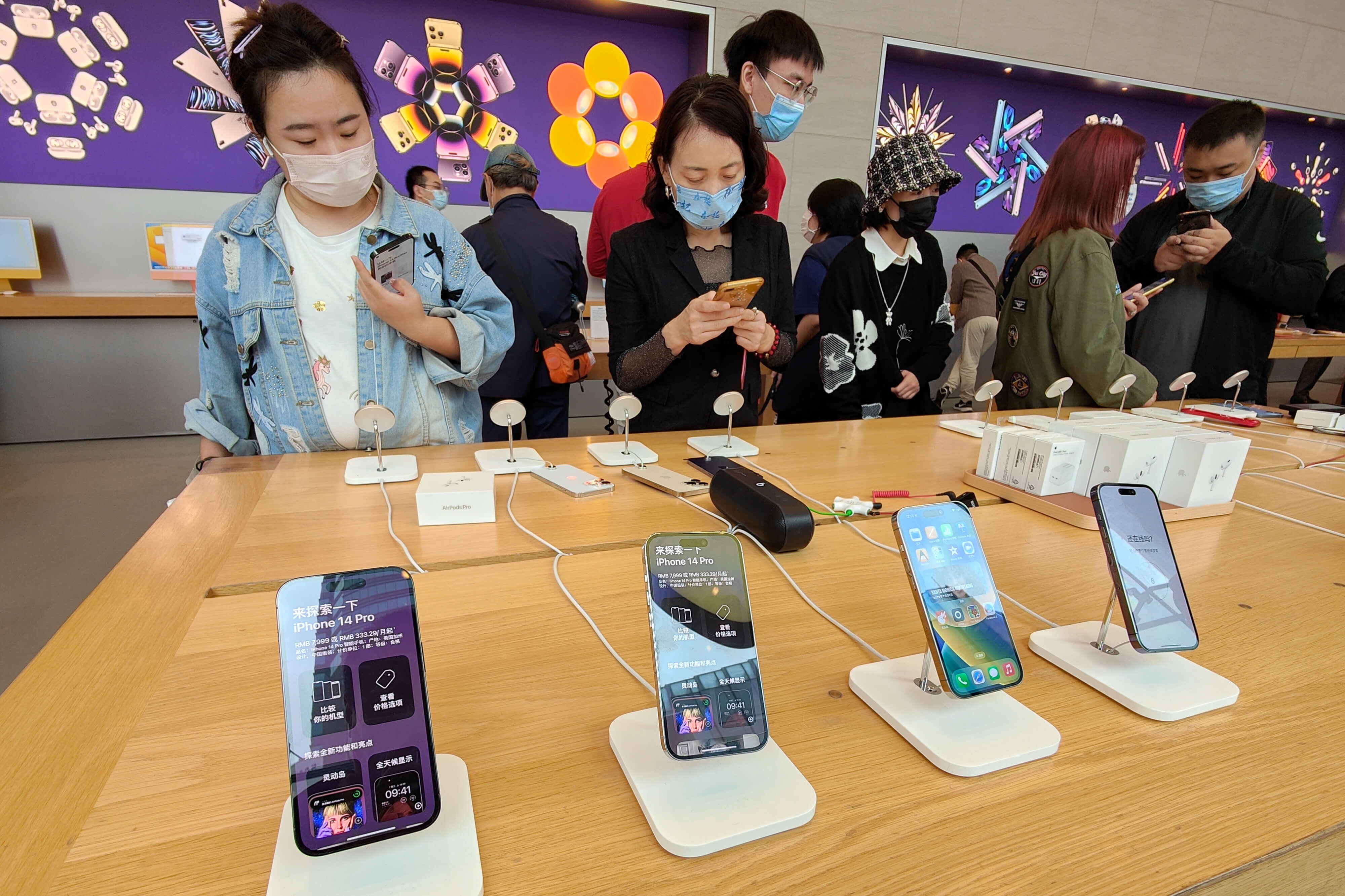 Okano-Heijmans-Klanten bekijken de iPhone14-serie in een Apple Store in Shanghai in november 2022. Reuters