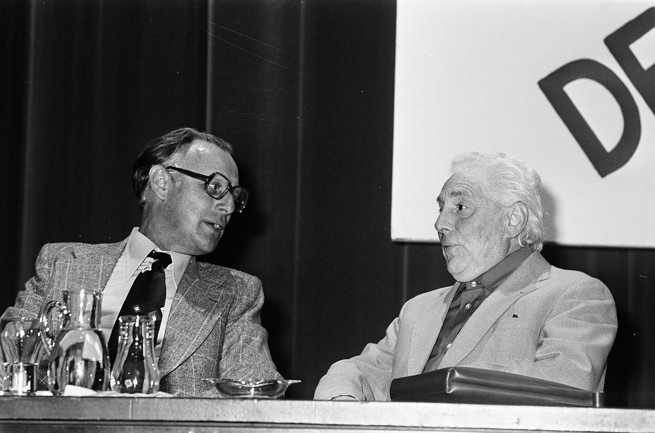Partijvoorzitter Henk Hoekstra (links) en erevoorzitter Paul de Groot tijdens een congres van de Communistische Partij Nederland (CPN) in de RAI te Amsterdam, 1975. © Wikimedia Commons.  