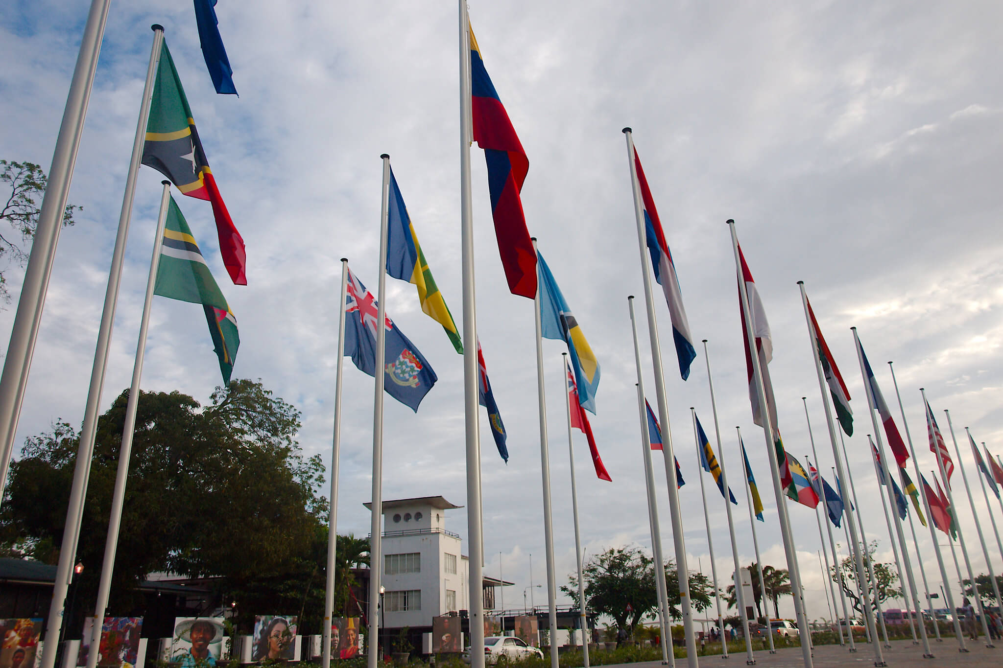 Vlaggen van de Caribische Gemeenschap (CARICOM) op het Onafhankelijkheidsplein in Paramaribo, met op de achtergrond De Nationale Assemblée. © Delphinidaesy / Flickr.