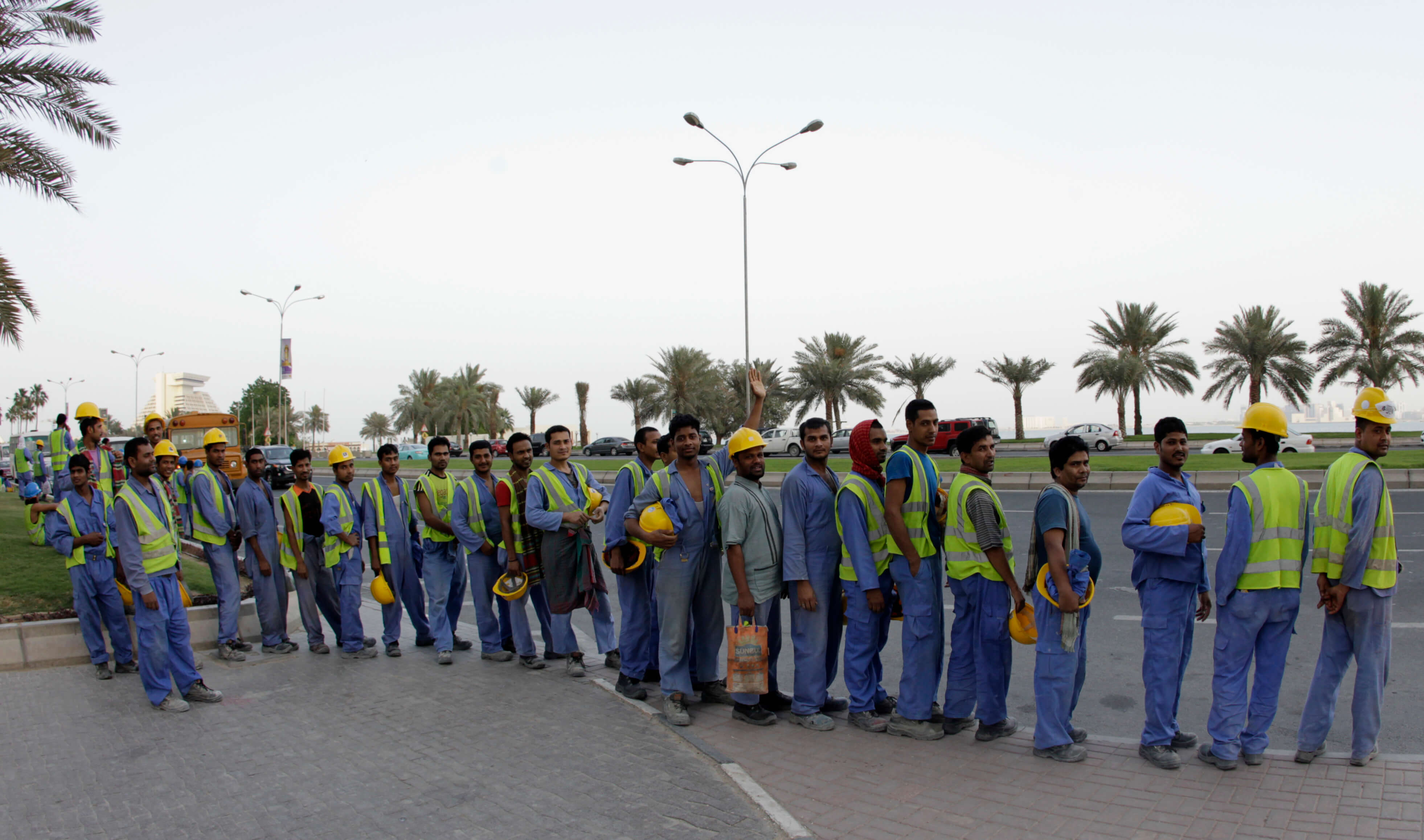 Reef - Buitenlandse bouwvakkers bij een bushalte in Doka, Qatar, in 2012. Reuters