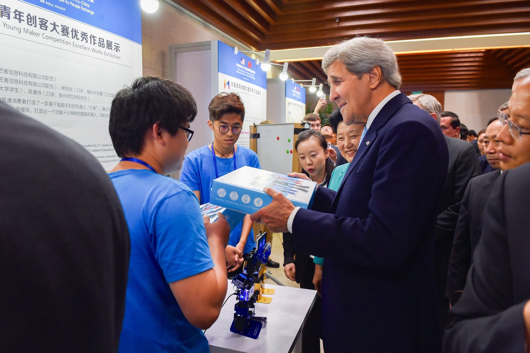 VanderLugt - Secretary of State John Kerry Looks at a Box Containing a Robot That Incorporates an iPhone Before a Meeting With Young Entrepreneurs in Beijing in 2016. US Department of State