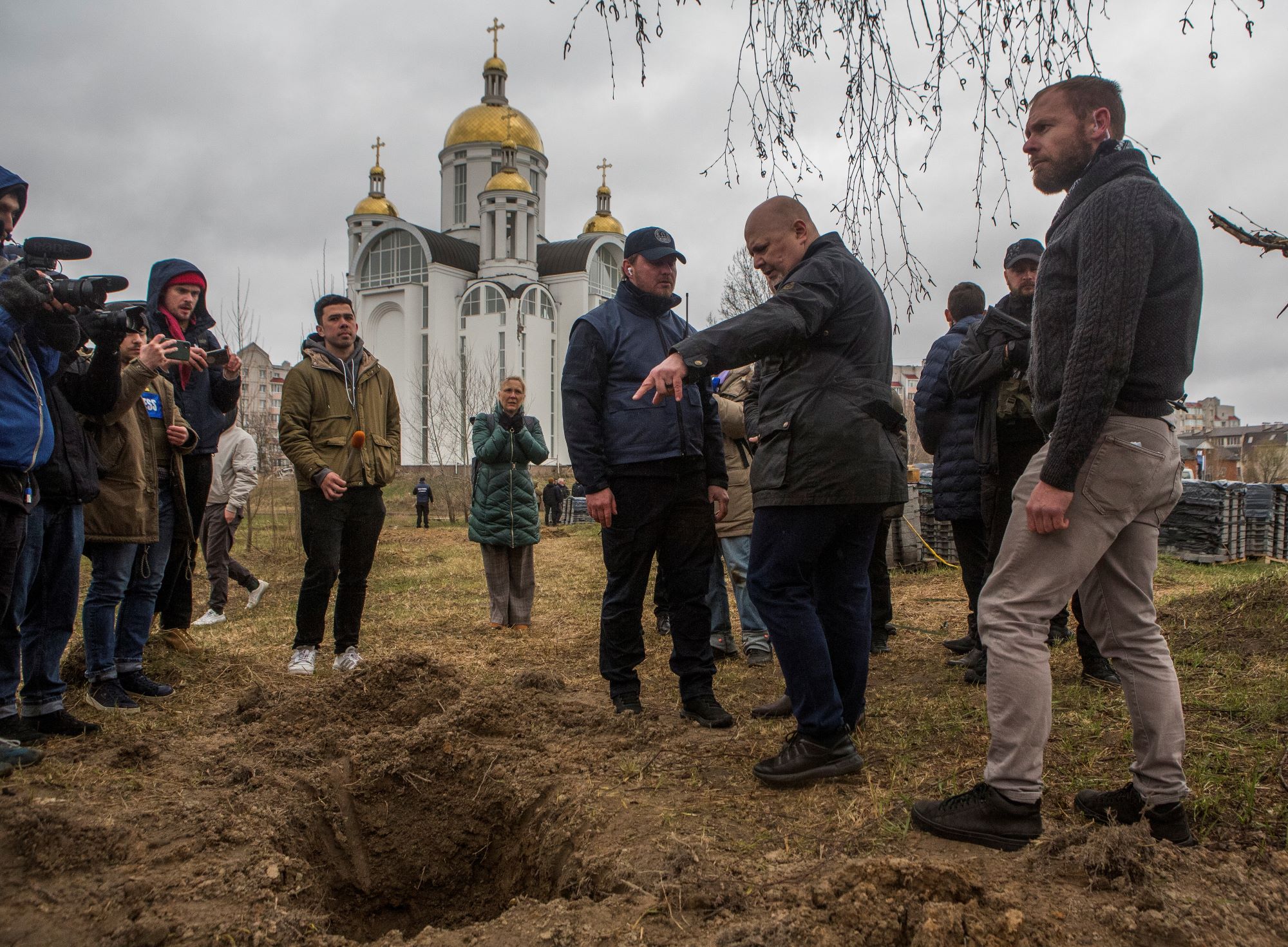 Vukusic-International Criminal Court (ICC) Prosecutor Karim Khan stands next to a grave where remains of three bodies were found, in the town of Bucha, outside Kyiv, Ukraine April 13, 2022. REUTERS