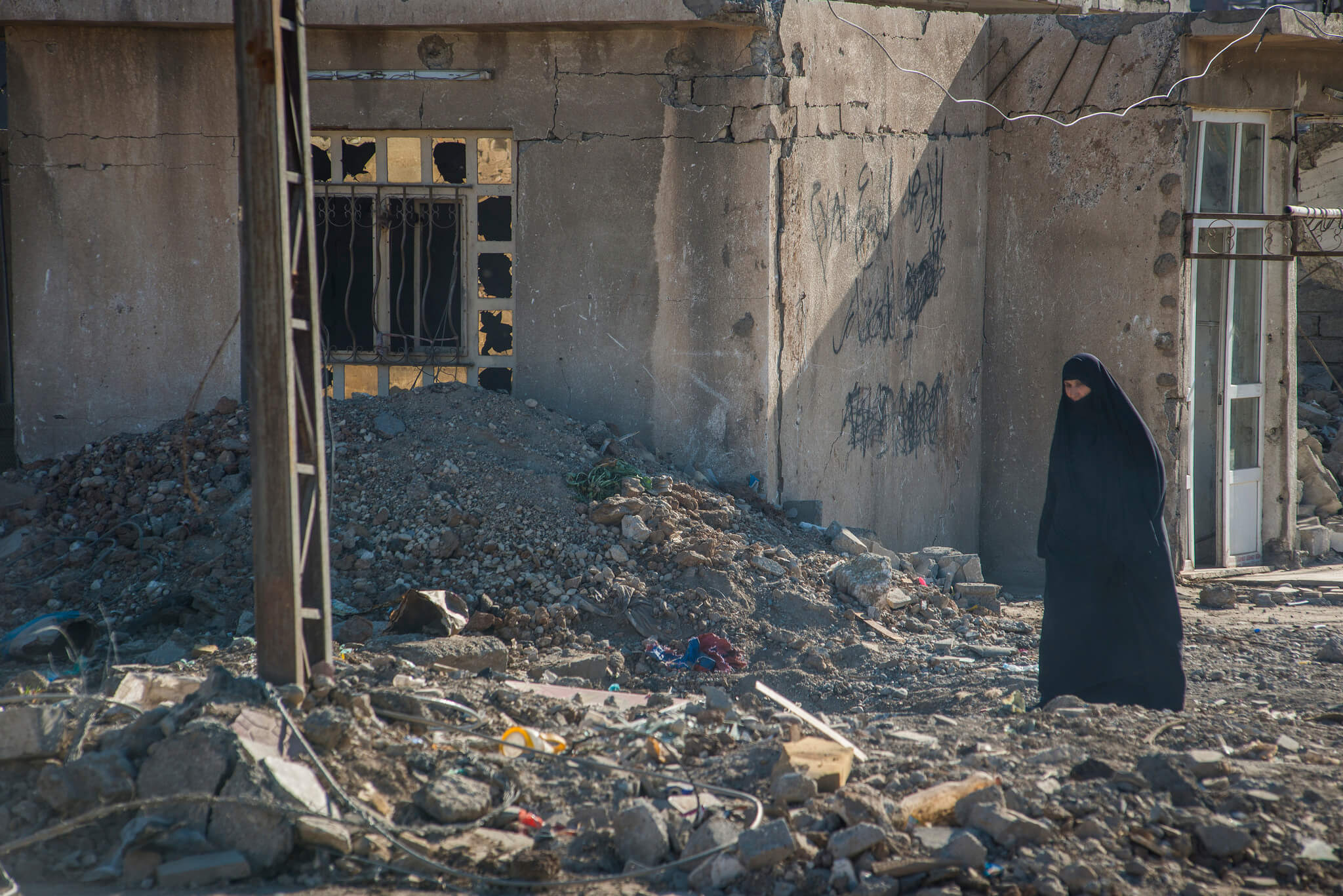 Een vrouw loopt in november 2017 door de verwoeste Iraakse stad Mosul.  